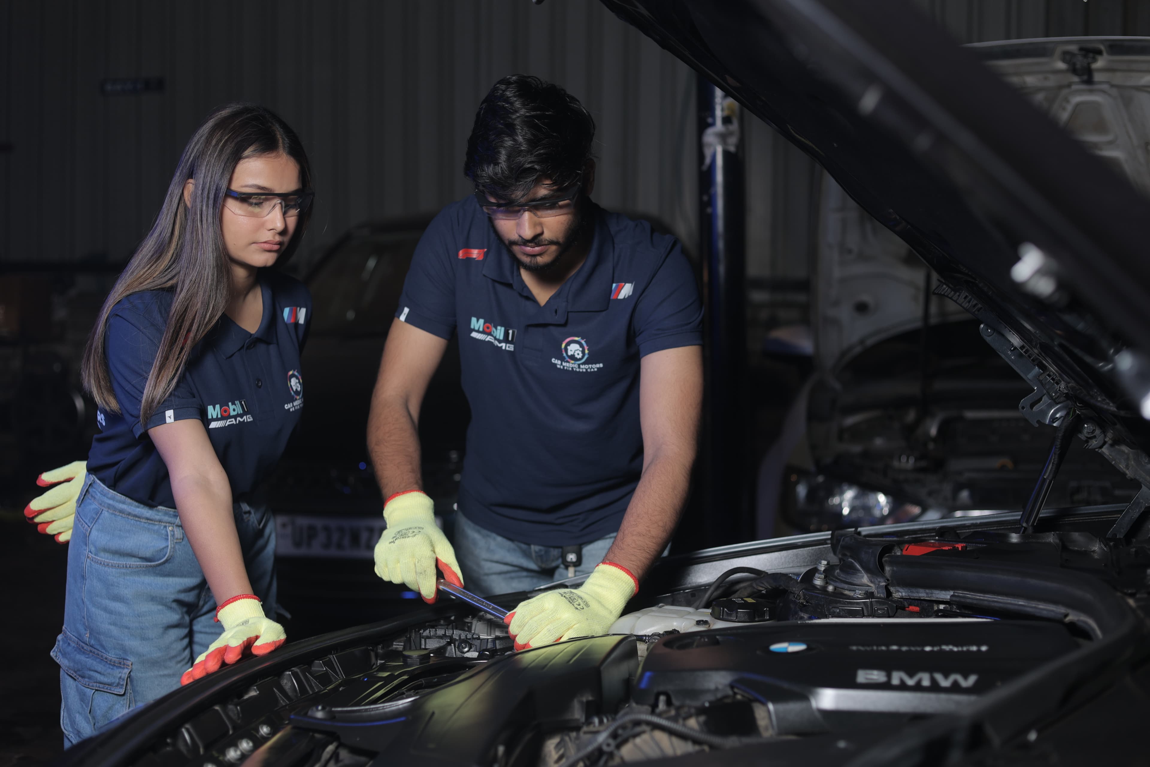 Two Car Medic Motors technicians working on a car engine